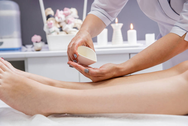 Beautiful young woman enjoying legs massage in spa salon. Cosmetology concept - Foto, immagini