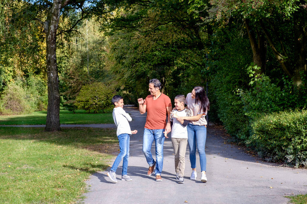 sétáló család két gyerekkel a parkban - Fotó, kép
