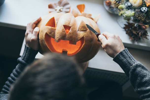 Homme coupe citrouille pour Halloween partie avec un couteau
 - Photo, image