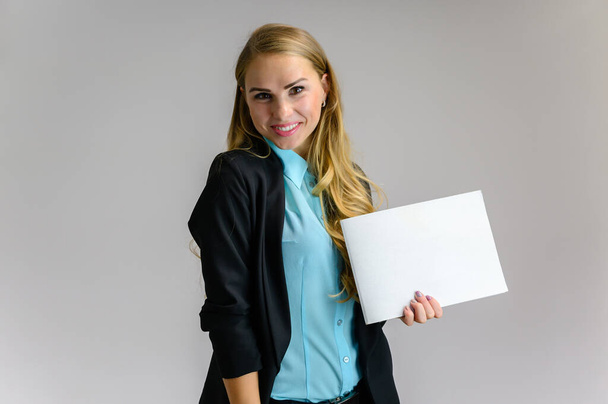 Portrait of a pretty blonde girl financial secretary with long curly hair in a business suit standing in the studio on a white background with emotions in different poses with a folder in his hands. - 写真・画像