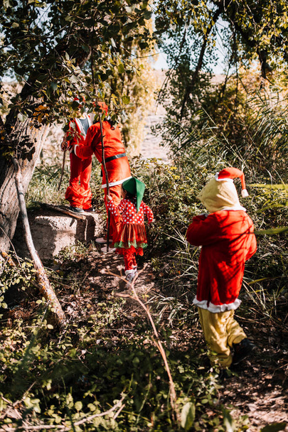 森のクリスマスに変装した人々のグループ - 写真・画像