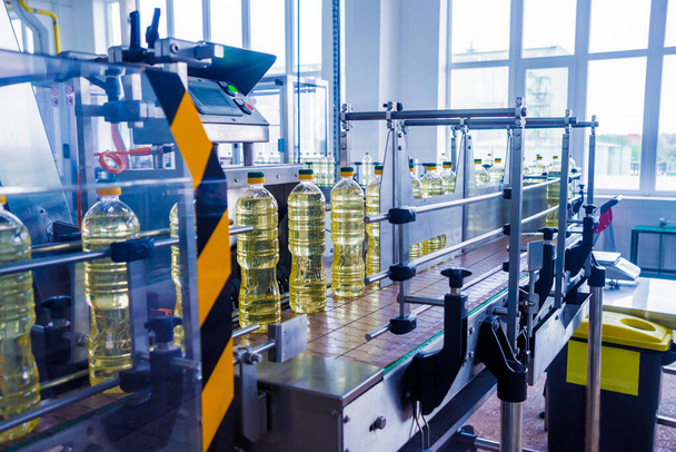 Bottling line of sunflower oil in bottles at plant, high technology concept, industrial background  - Photo, Image