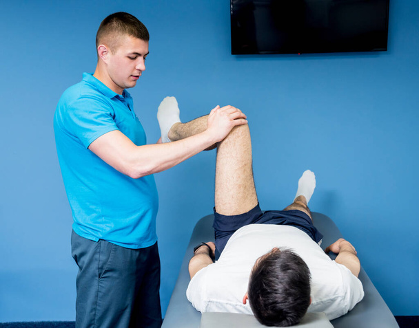 Rehabilitation therapy. Physiotherapist working with young male patient in the rehabilitation center - Foto, Imagem
