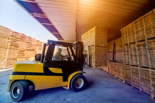 Forklift loader load lumber into a dry kiln. Wood drying in cont - 写真・画像