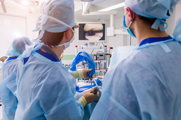 Arthroscope surgery. Orthopedic surgeons in teamwork in the operating room with modern arthroscopic tools. Knee surgery. Hospital background - Φωτογραφία, εικόνα