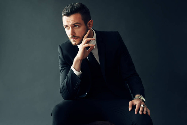 Portrait of elegant young man in suit on black background - Fotoğraf, Görsel
