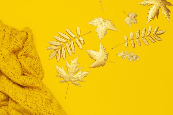 Outono plana composição leigos. Camisola fêmea de malha amarela alaranjada e folhas douradas na vista superior de fundo amarelo. Acessórios de queda de mulher na moda. Cozy Knit Jumper elegante roupas de senhora
 - Foto, Imagem
