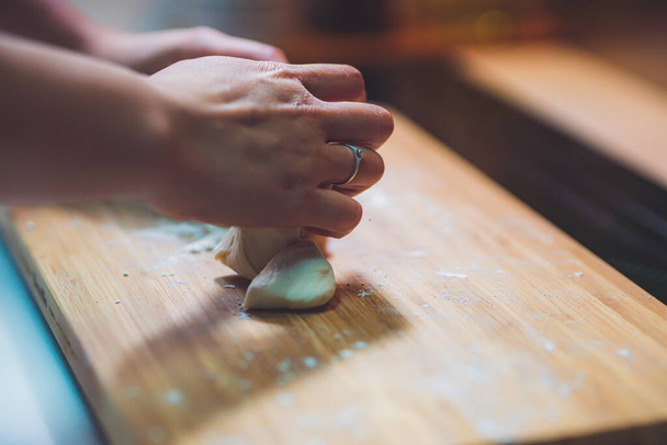 Kobieta przygotować pierogi skóry, Dokonywanie ciasta na drewnianym stole - Zdjęcie, obraz