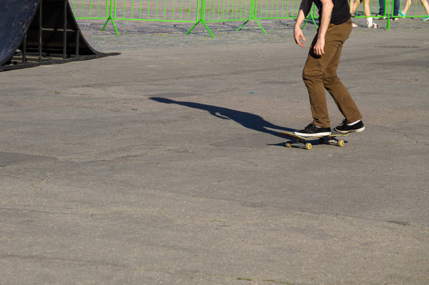 Skateboarder legs riding skateboard at skatepark  - Photo, Image