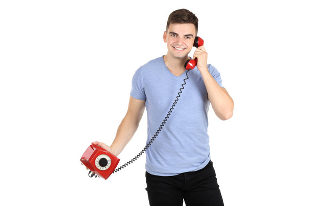 Young man with handset and telephone on white background - Foto, Imagem