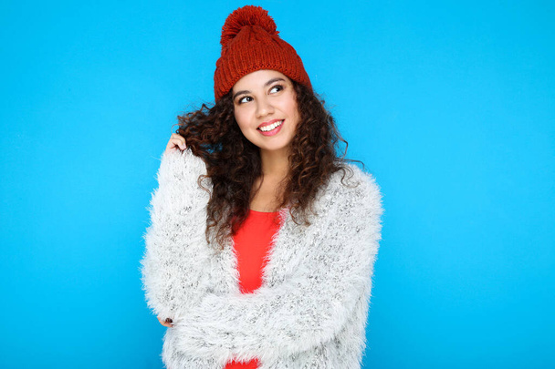 Beautiful american woman in fashion clothing and red hat on blue background - Fotografie, Obrázek