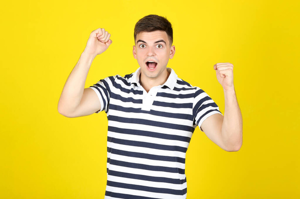 Young surprised man on yellow background - Φωτογραφία, εικόνα
