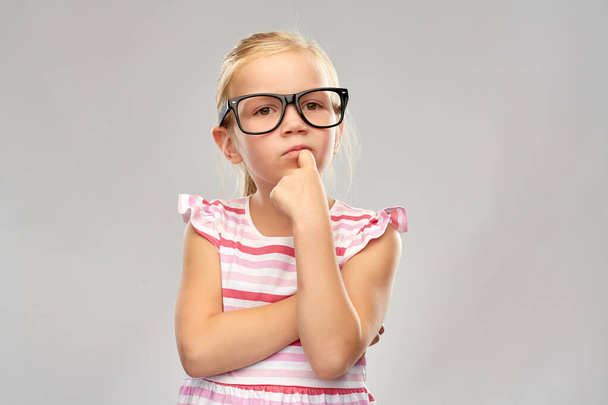 cute little girl in black glasses thinking - Foto, immagini