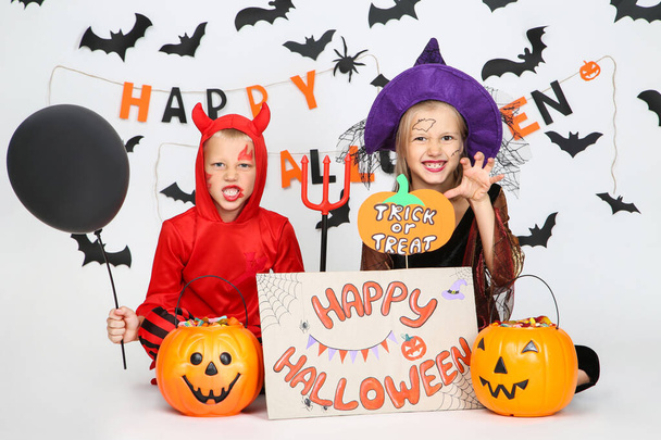 Young girl and boy in costumes with pumpkin buckets and text Hap - Foto, Imagen