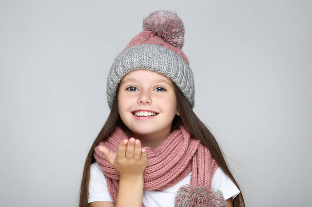 Little girl in hat and scarf on grey background - Fotografie, Obrázek