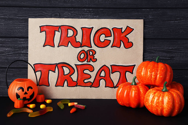 Text Trick or Treat with halloween pumpkins and candies on woode - Фото, зображення