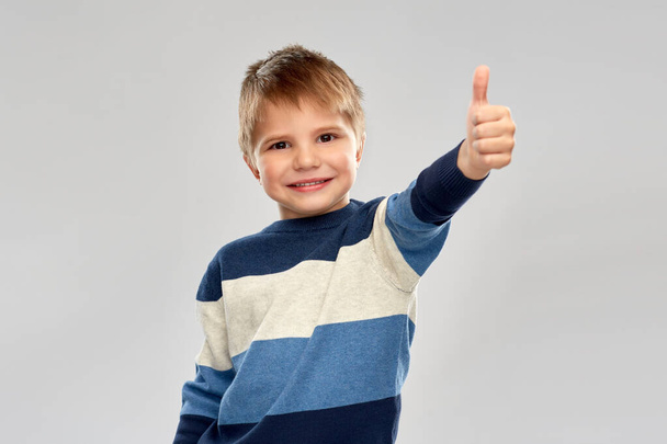 little boy in striped pullover showing thumbs up - Фото, зображення