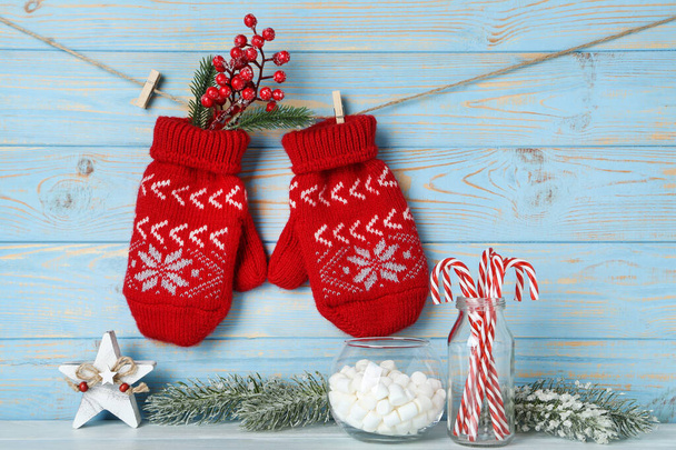 Knitted mittens with fir tree branches, candies, marshamllow and - Photo, image