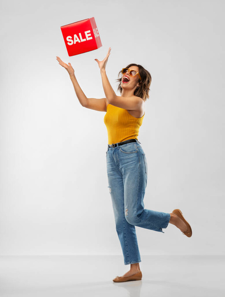 happy smiling young woman posing with sale sign - Foto, imagen