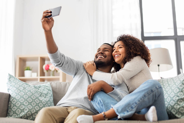 happy couple with smartphone taking selfie at home - Zdjęcie, obraz