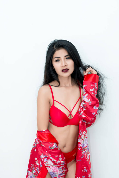 Portrait of sexy asian woman in red dress on white background - Foto, Imagen