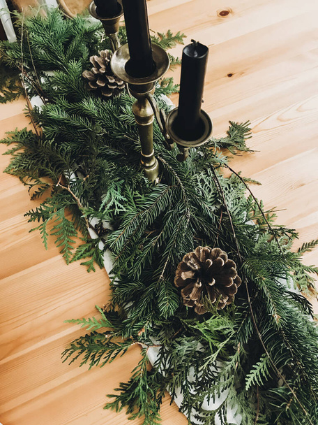 テーブルのクリスマス素朴な装飾。ヴィンテージキャンドルスティック、松の枝 - 写真・画像