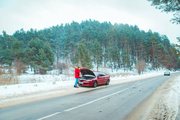 uomo in piedi vicino rotto auto a bordo strada nevicato tempo invernale
 - Foto, immagini