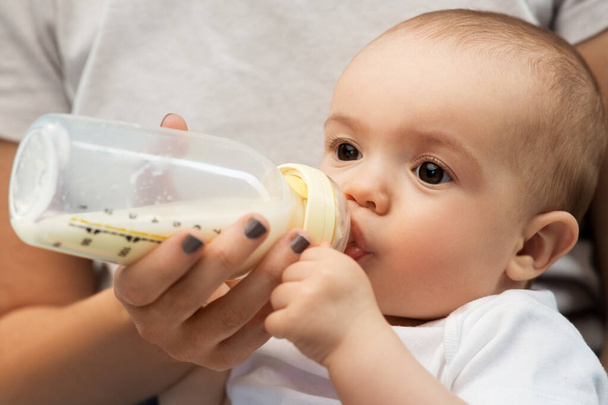 close up of mother feeding baby with milk formula - Fotoğraf, Görsel