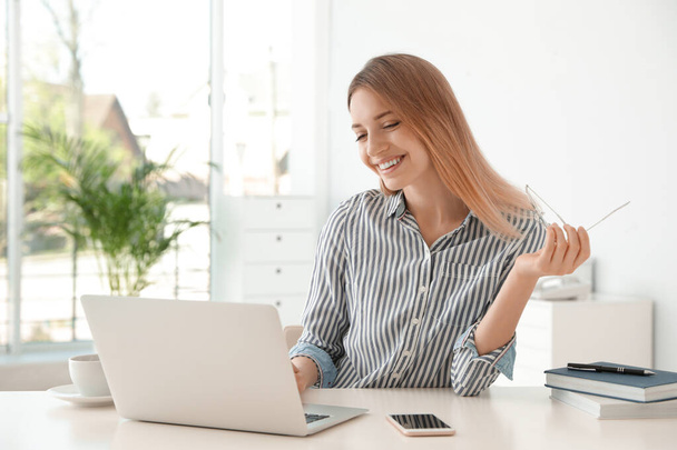 Young businesswoman using laptop at table in office - Foto, immagini