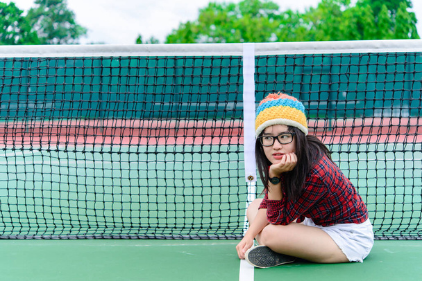 Hipster asian girl pose for take a photo,Fashion portrait pretty woman at tennis court,lifestyle of modern teenage thai girl - Photo, Image
