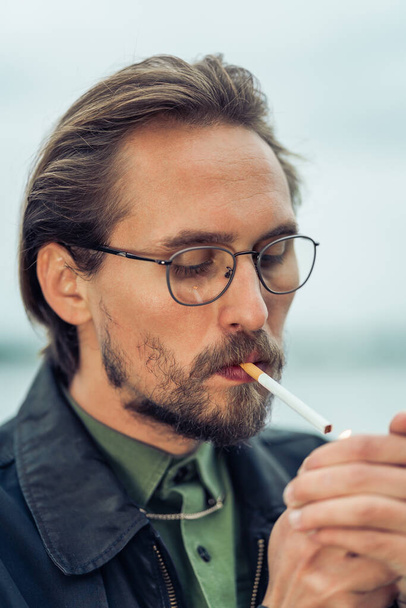 Young handsome man lighting up cigarette - Photo, Image