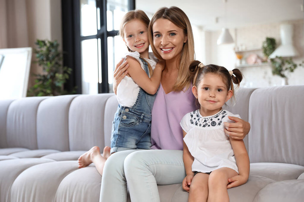 Cute little girls with their mother in living room - Foto, Imagem