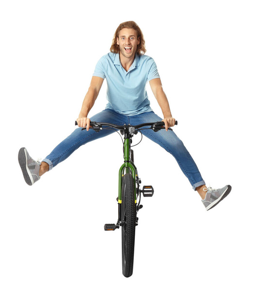 Happy young man riding bicycle on white background - Zdjęcie, obraz