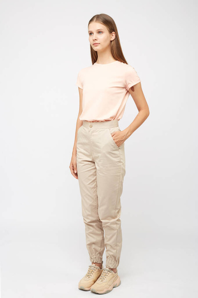 girl in beige cargo pants and a t-shirt - Фото, изображение