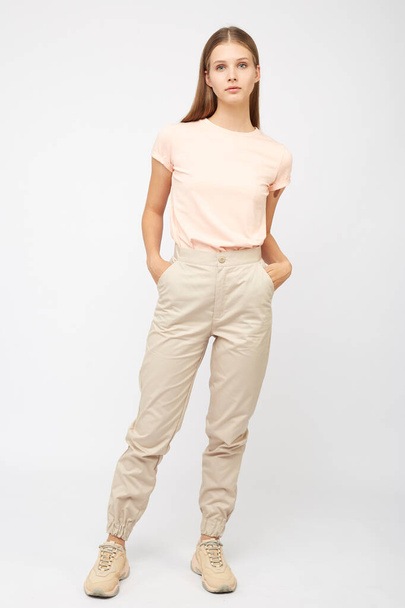 girl in beige cargo pants and a t-shirt - Foto, afbeelding