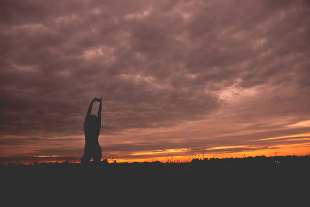 Silueta fit ženy hrát jógu při západu slunce - Fotografie, Obrázek