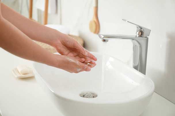Woman washing hands indoors, closeup. Bathroom interior - Фото, изображение