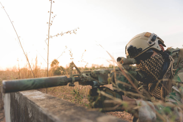 Soldier with weapon behind bunker - Foto, Imagen