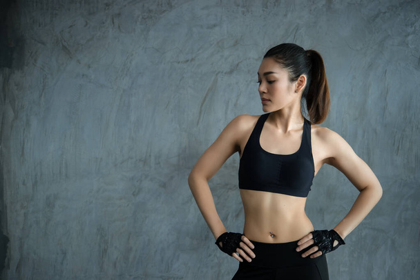 Close up asian beautiful sportswoman wear sport bra on wall of gym, Thailand love health, Slim woman workout concept
 - Фото, изображение
