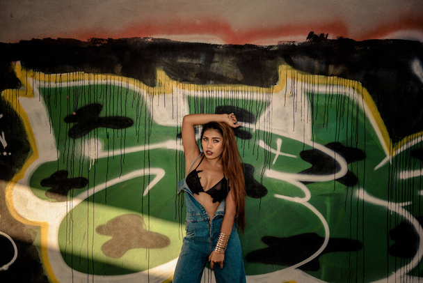 Portret azjatyckiego sexy hipster dziewczyna show biustonosz na ścianie graffity, Ziarno i hałas został dodany do efektu filmu fotograficznego. - Zdjęcie, obraz