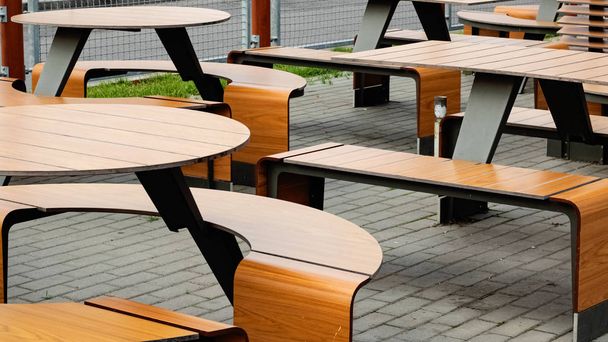 Fa asztalok és székek egy kávézóban a szabadban - Fotó, kép