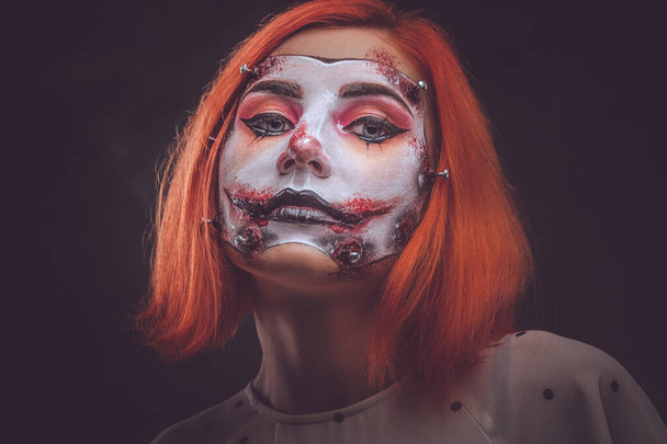 Портрет рыжей девушки со страшным кукольным искусством на лице
 - Фото, изображение