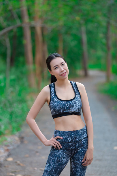 Азійська спортивна жінка розтягує тіло, дихає свіжим повітрям у парку, Таїланд, Фітнес і займається концепцією, бігає в парку, зігріває тіло - Фото, зображення