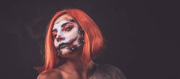 Portret van roodharig meisje met enge poppenkunst op gezicht - Foto, afbeelding