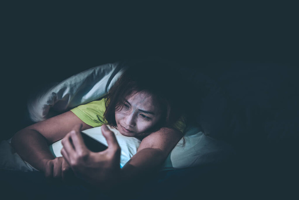 Asian woman play smartphone in the bed at night,Thailand people,Addict social media,Play internet all night - Fotografie, Obrázek
