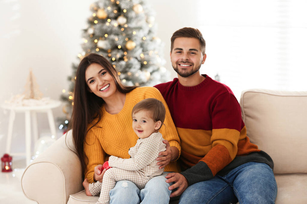 Szczęśliwa rodzina z uroczym dzieckiem w domu. Święta Bożego Narodzenia - Zdjęcie, obraz