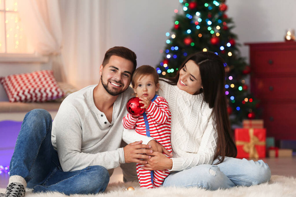 Happy family with cute baby at home. Christmas celebration - Фото, изображение