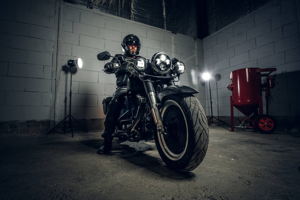 Biker con su moto en el garaje
 - Foto, imagen