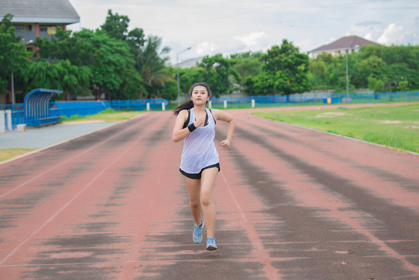 Asian beautiful woman running on the track,Thailand people,The runners run training for the competition. - 写真・画像
