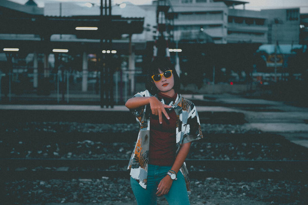 Portrait of asian hipster girl on sunset at railway in vintage style - Zdjęcie, obraz